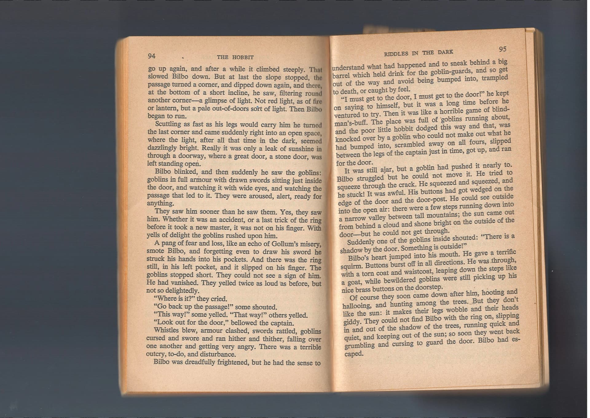 Photograph of The Hobbit book open to pages 94-95, showing Chapter V: Riddles in the Dark